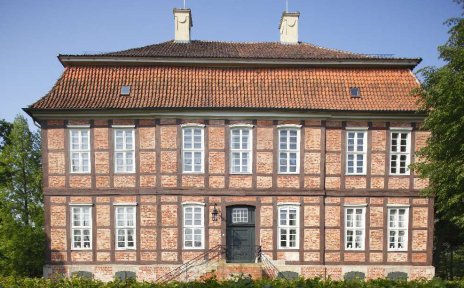 Ein rot geklinkertes herrschaftliches Gebäude umgeben von Grün Ein rot geklinkertes herrschaftliches Gebäude umgeben von Grün