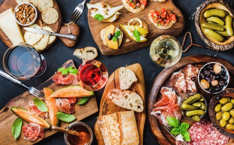 Bunte Antipastiplatte mit Baguette, Oliven, Salami und bunten Leckereien Bunte Antipastiplatte mit Baguette, Oliven, Salami und bunten Leckereien