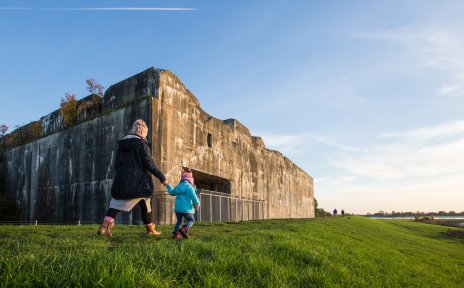 Ein großer Hochbunker, im Vordergrund eine Mutter mit ihrem Kind; Quelle: WFB/Jens Lemkühler Ein großer Hochbunker, im Vordergrund eine Mutter mit ihrem Kind; Quelle: WFB/Jens Lemkühler