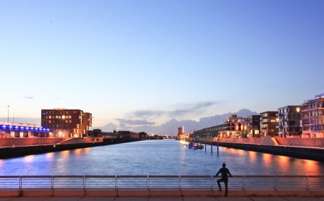 Ein Mann steht am Kopf des Hafenbeckens Europahafen und blickt auf den Sonnenuntergang Ein Mann steht am Kopf des Hafenbeckens Europahafen und blickt auf den Sonnenuntergang