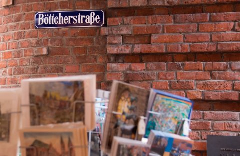 Das Straßenschild der Böttcherstraße ist dunkelblau mit weißer Schrift und an einer roten Backsteinwand angebracht. Das Straßenschild der Böttcherstraße ist dunkelblau mit weißer Schrift und an einer roten Backsteinwand angebracht.