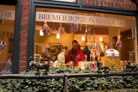 Ein Foto von Außen in das Fenster der Bonbon Manufaktur Böttcherstraße. Leckere Bonbons und große Lollis sind in allen Farben zu sehen. Ein Foto von Außen in das Fenster der Bonbon Manufaktur Böttcherstraße. Leckere Bonbons und große Lollis sind in allen Farben zu sehen.