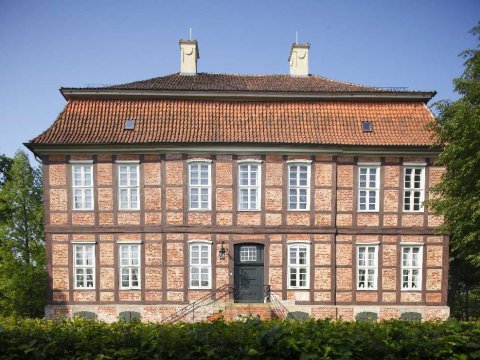 Ein rot geklinkertes herrschaftliches Gebäude umgeben von Grün Ein rot geklinkertes herrschaftliches Gebäude umgeben von Grün