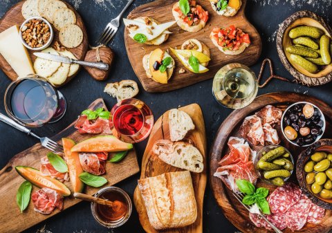 Bunte Antipastiplatte mit Baguette, Oliven, Salami und bunten Leckereien Bunte Antipastiplatte mit Baguette, Oliven, Salami und bunten Leckereien