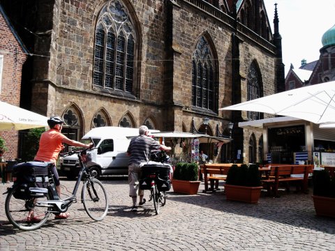 Zwei Radfahrer schieben ihr Rad durch die Bremer Innenstadt Zwei Radfahrer schieben ihr Rad durch die Bremer Innenstadt