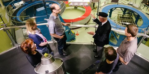 Eine Gruppe Besucher*innen wird durch Räumlichkeiten bei Airbus geführt. Eine Gruppe Besucher*innen wird durch Räumlichkeiten bei Airbus geführt.