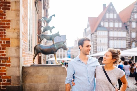 Eine Frau und ein Mann stehen vor den Bremer Stadtmusikanten. Eine Frau und ein Mann stehen vor den Bremer Stadtmusikanten.