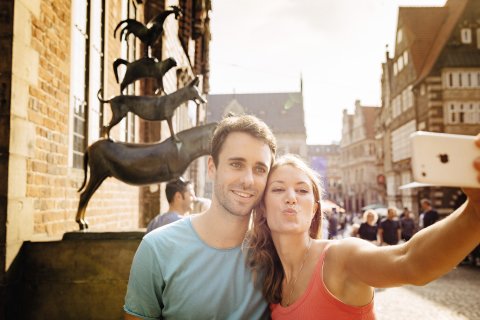 Ein Pärchen macht ein Selfie vor den Bremer Stadtmusikanten. Ein Pärchen macht ein Selfie vor den Bremer Stadtmusikanten.