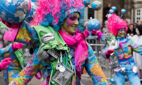Eine mit Weltkugeln und bunten Farben geschmückte Frau zelebriert den Samba Karneval Eine mit Weltkugeln und bunten Farben geschmückte Frau zelebriert den Samba Karneval