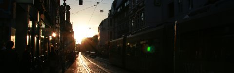 Die Sonne steht tief über dem Steintor mit Passanten und Straßenbahn. Die Sonne steht tief über dem Steintor mit Passanten und Straßenbahn.