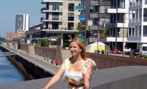 Eine Dame fährt vor Neubauten Fahrrad Eine Dame fährt vor Neubauten Fahrrad