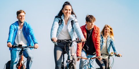 Vier junge Menschen auf ihren Fahrrädern Vier junge Menschen auf ihren Fahrrädern