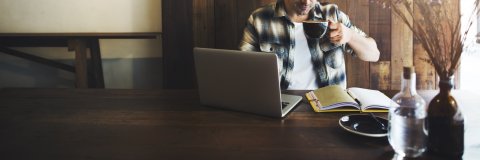 Bild von einem Mann mit Laptop in einem Café Bild von einem Mann mit Laptop in einem Café
